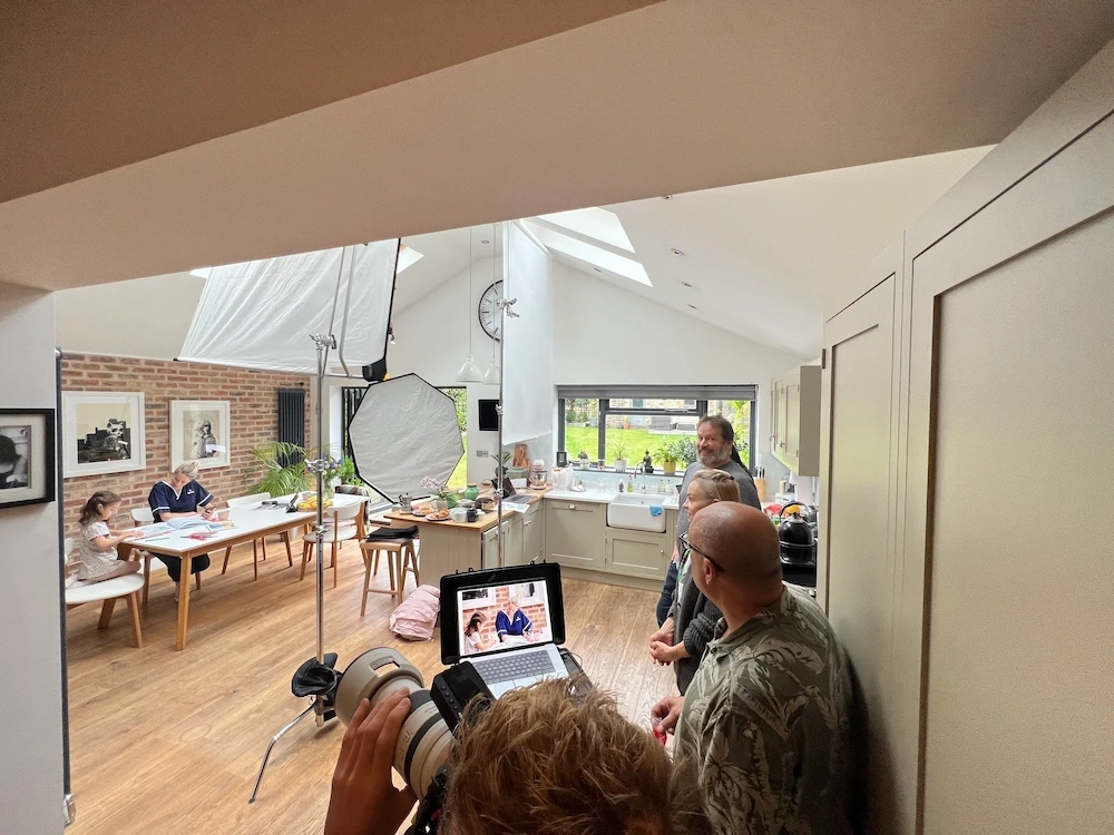 A small team setting up a photography shoot in a home kitchen