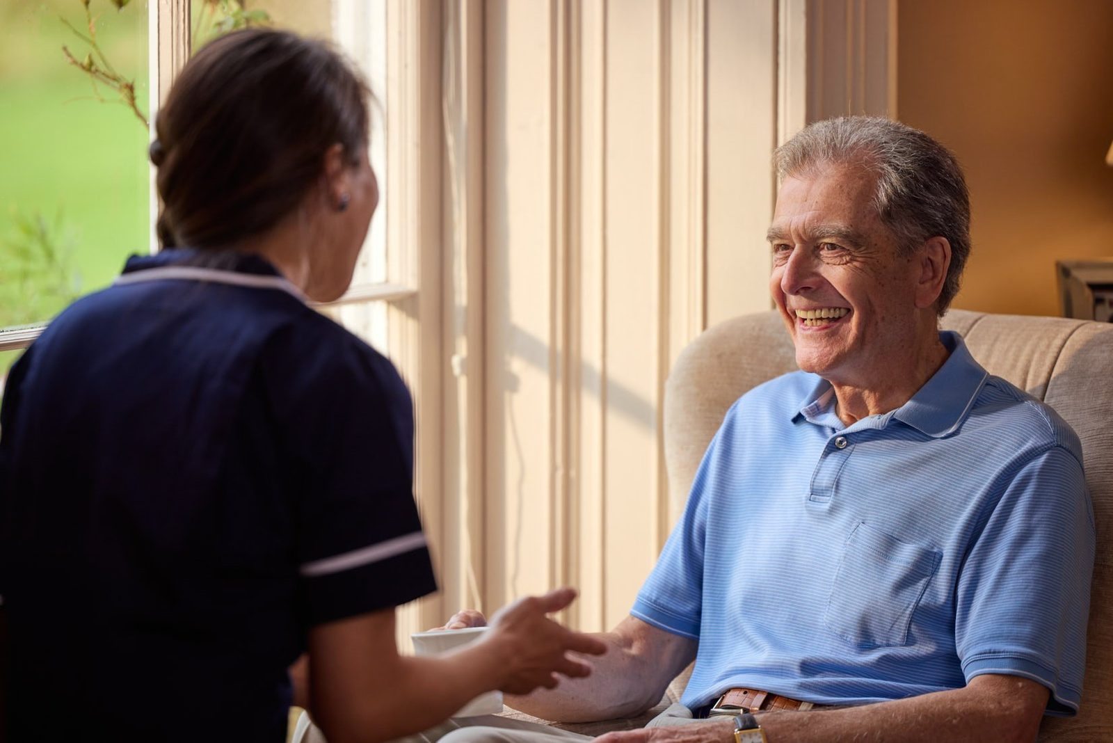 Bluebird Care: a carer chatting with a man in an armchair