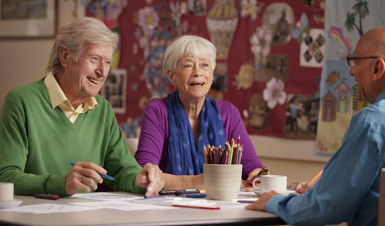 Elizabeth Finn Homes: two residents and a team member doing crafts together at a table