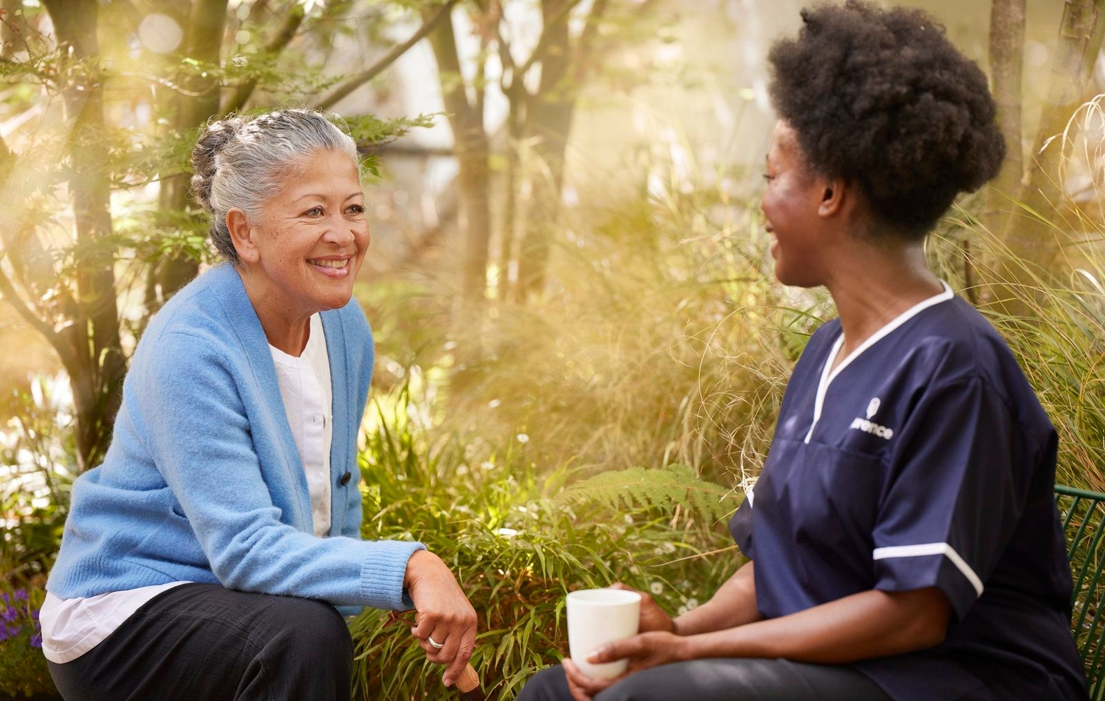 Florence: a nurse and an older woman laughing together in a garden